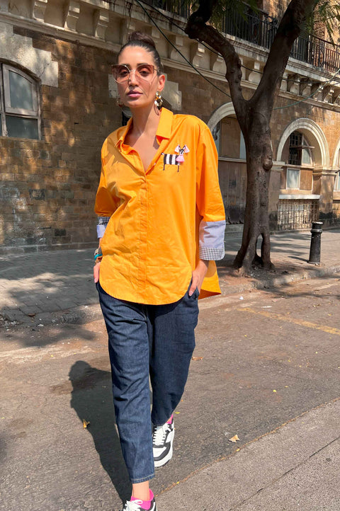 Marty mango orange cotton shirt for women with zebra embroidery and striped sleeve cuffs, front view with dark denim pants