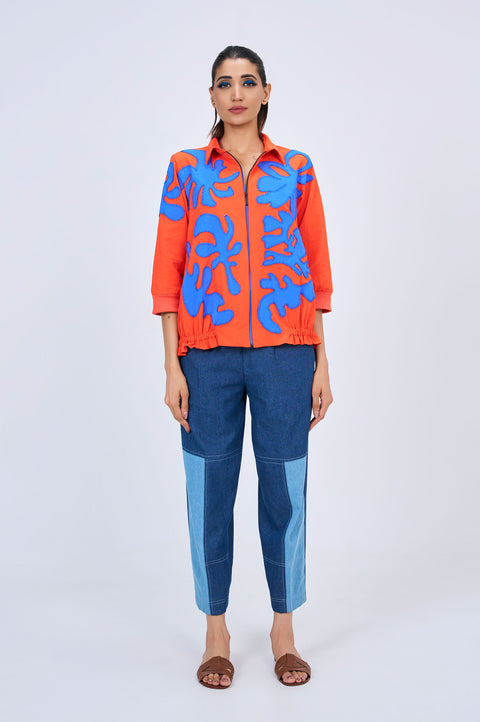 Flame orange co-ord set for women with blue appliqué shirt and denim pants, full-length view showing the contrast-panel pants