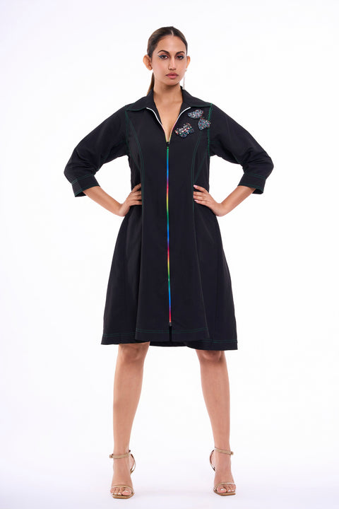 Mariposa black dress for women with embellished butterflies, rainbow zipper and green stitching, front view with hands on hips
